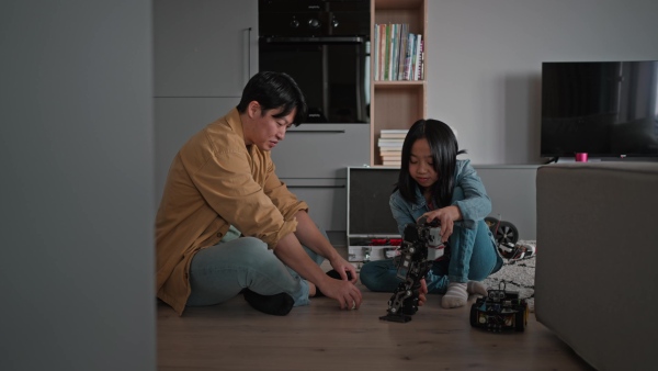 Father teaching his curious daughter about STEM, robotics, and discussing technology while playing with the robot.