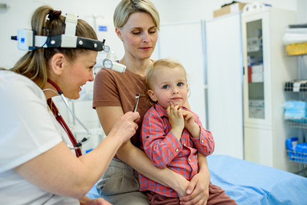 Otolaryngologist examining toddler in pediatric clinic, ENT exam.