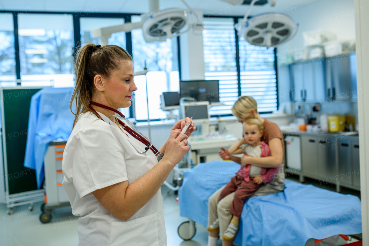 Pediatrician preparing injection for child immunization. Preventive care.