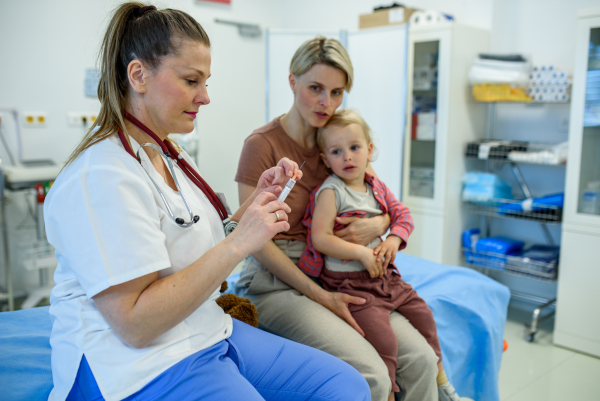 Toddler getting vaccinated during pediatric checkup. Preventive care.