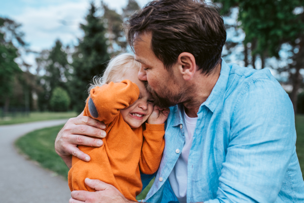 Father comforting young son during his emotional moment in park