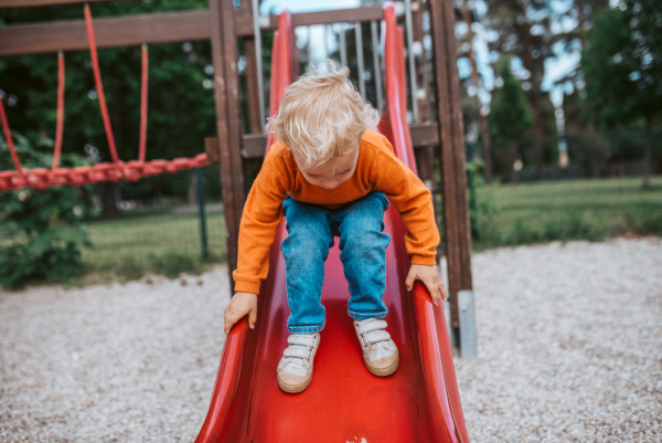 Little boy getting ready to slide. Boy having fun on playground.