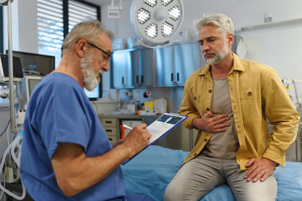 Patient explaing his health issues to older doctor. Medical examination.