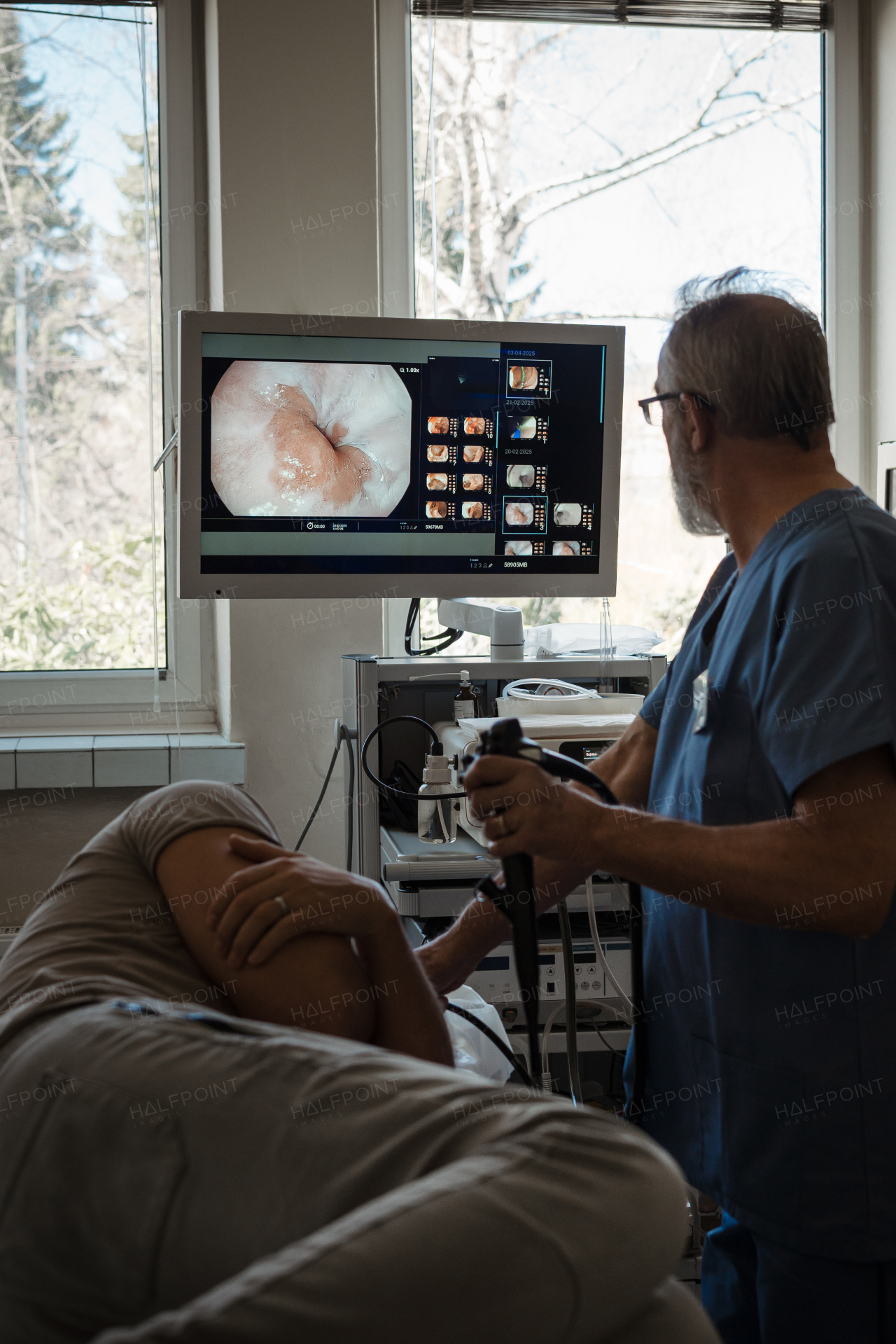 Doctor looking at monitior during gastroscopy procedure, examining upper digestive tract. Medical procedure.