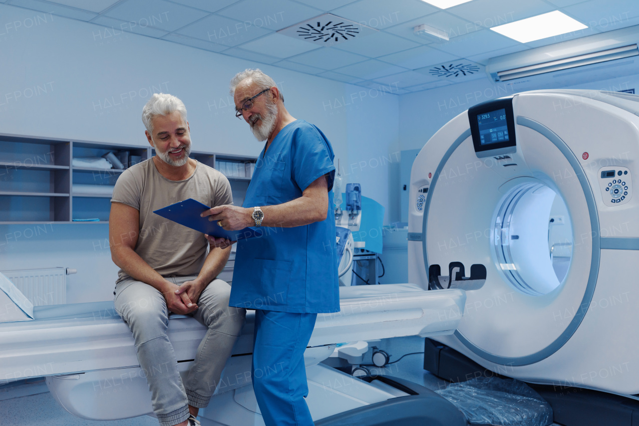 Doctor explaining CT scan results to male patient in hospital setting