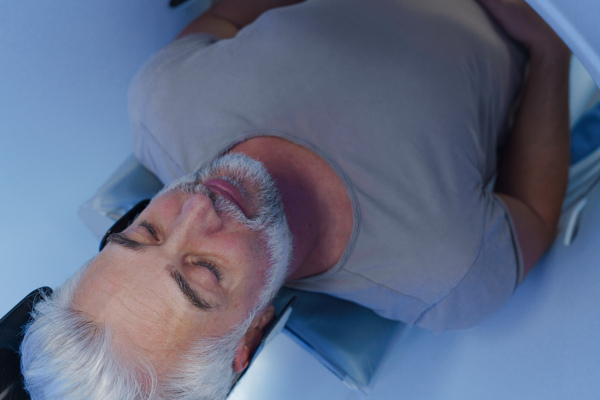 Male patient undergoing CT scan examination in a hospital.