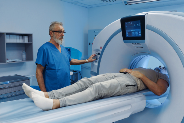 Male patient undergoing CT scan examination in hospital., hospital setting