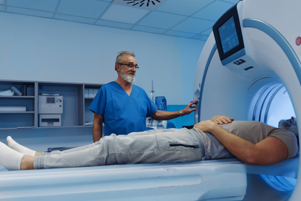 Male patient undergoing CT scan examination in hospital., hospital setting