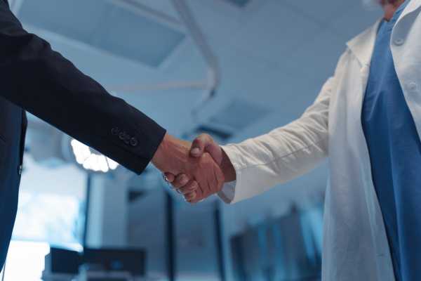Hospital business handshake in medical environment. Strategic collaboration in medical industry.