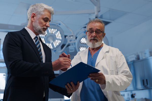 Doctor signing contract with pharmaceutical representative, successful deal.