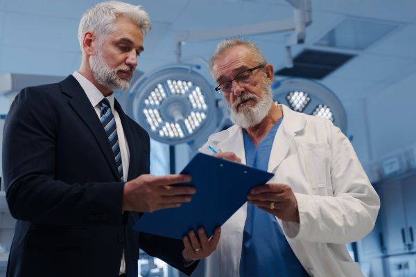 Doctor signing contract with pharmaceutical representative, successful deal.