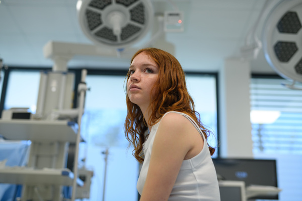 Teenage girl waiting for medical examination in hospital. Portrait of adolescent patient.