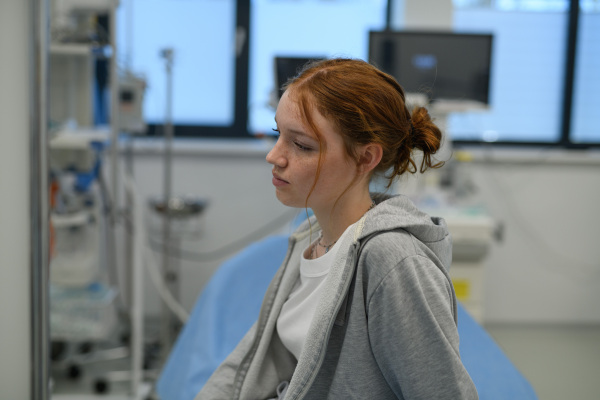 Teenage girl waiting for medical examination in hospital. Portrait of adolescent patient.