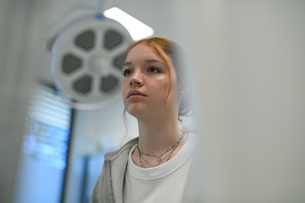 Anxious teenage girl waiting for medical examination in hospital. Portrait.