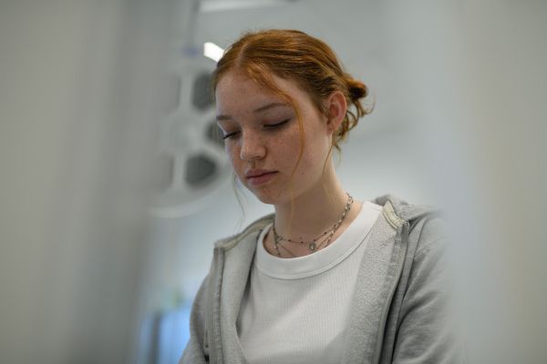 Teenage girl waiting for medical examination in hospital. Portrait of adolescent patient.