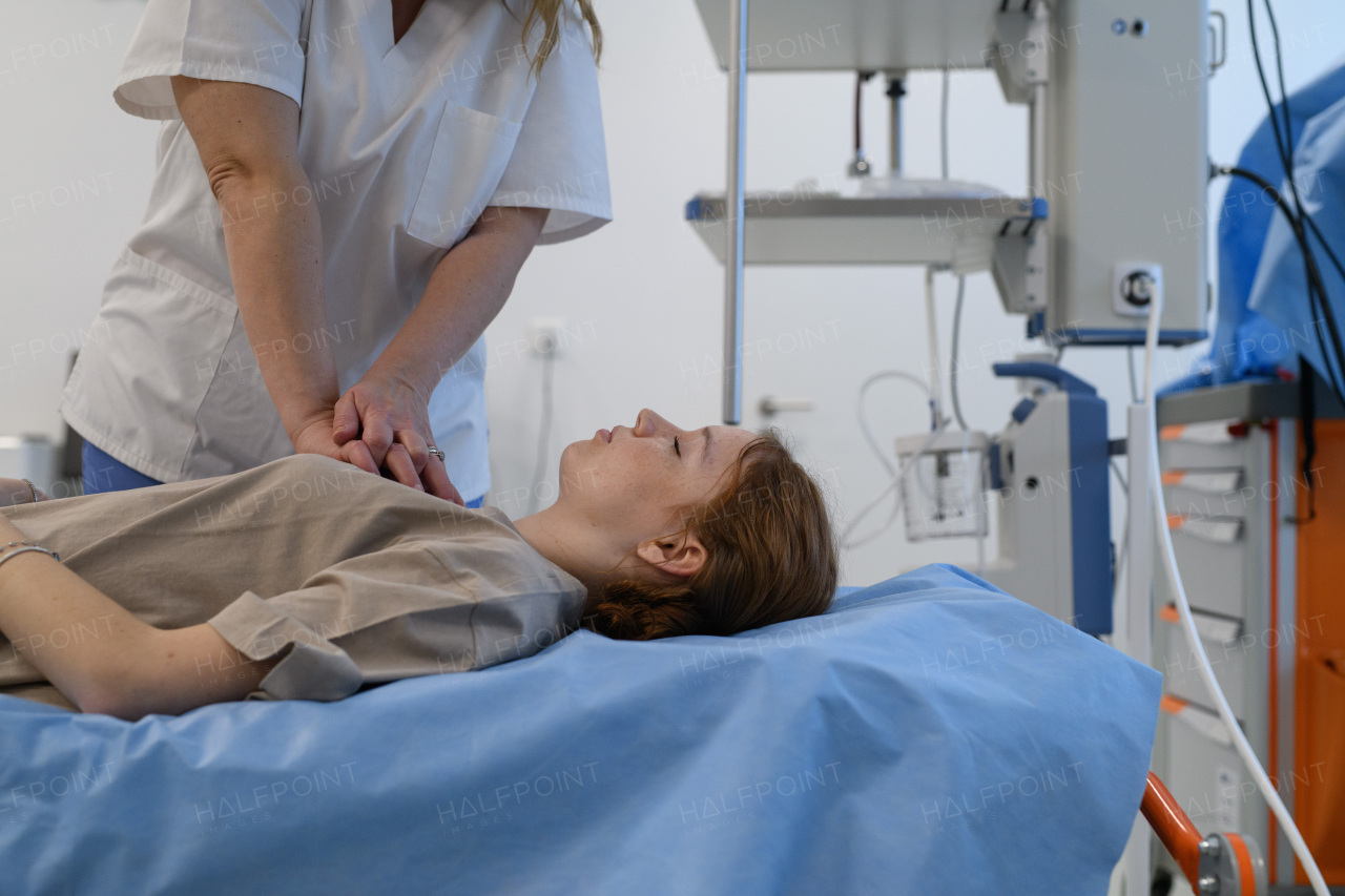 Doctors performing CPR on teenage patient in critical condition, emergency resuscitation.