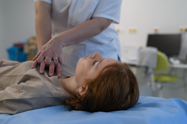 Doctors performing CPR on teenage patient in critical condition, emergency resuscitation.