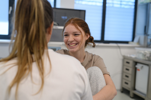 Teenage girl confiding in female doctor about personal and health problems.