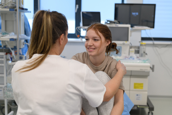Teenage girl confiding in female doctor about personal and health problems.