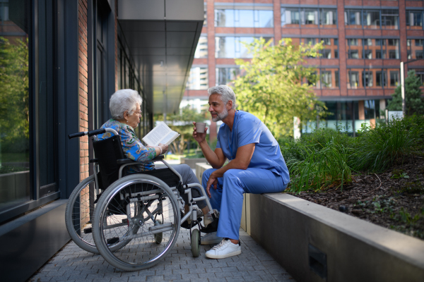 Senior woman in wheelchair reading poems to male caregiver.