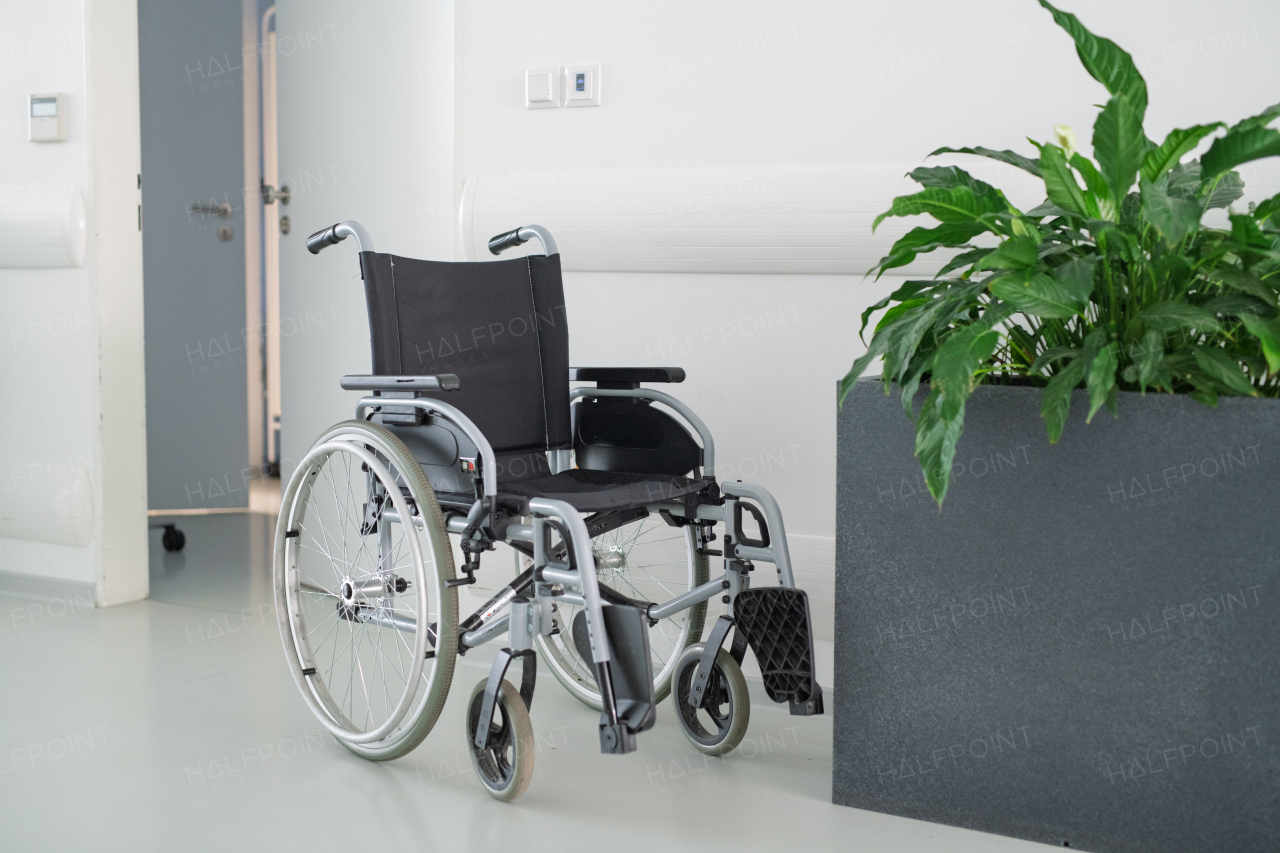 Hospital wheelchair without patient in hospital hallway.