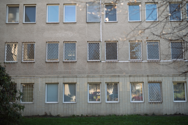 Old hospital building with barred windows and worn facade