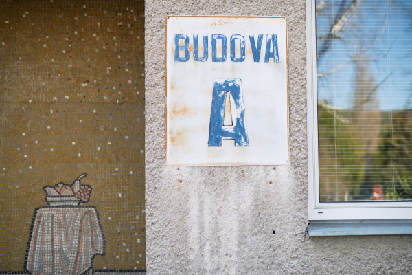 Old hospital building with faded sign on the wall.