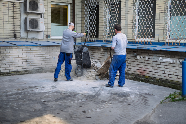 Construction workers clearing rubble outside hospital building