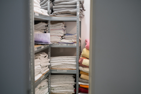 Hospital linen storage with folded towels and blankets on shelves
