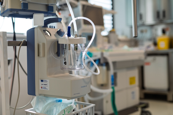 Medical suction device in hospital room with connected tubing
