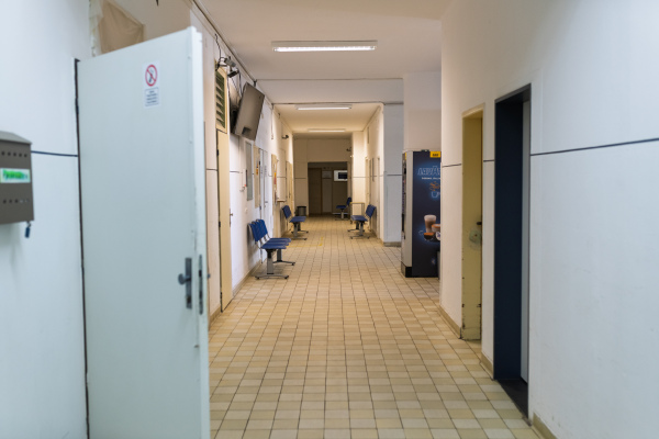 Worn corridor in municipal hospital with multiple clinics and seating