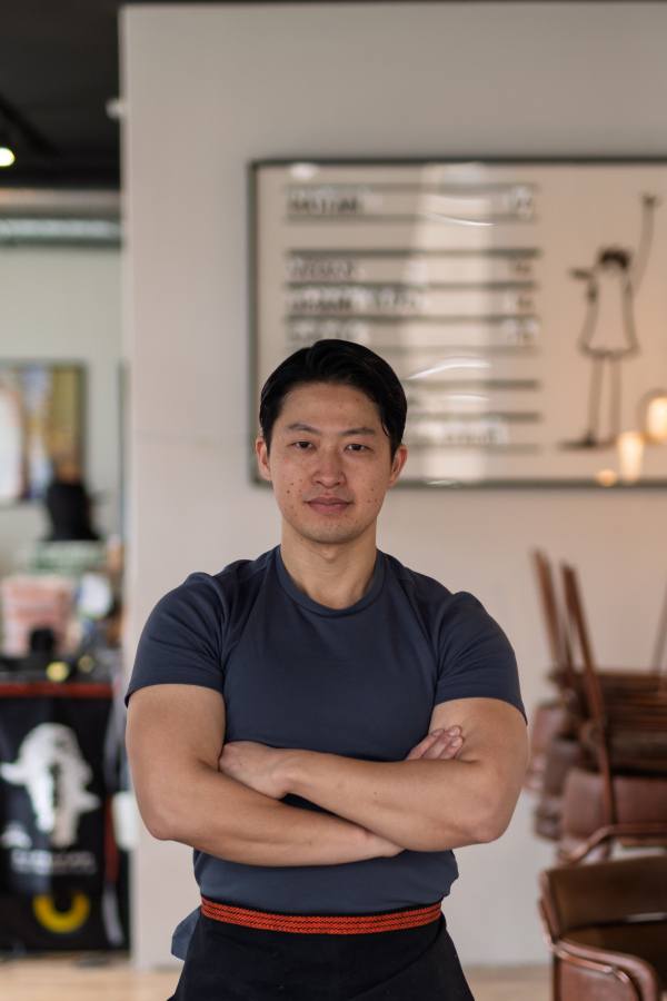 Athletic Asian man looking away in casual setting, smiling.