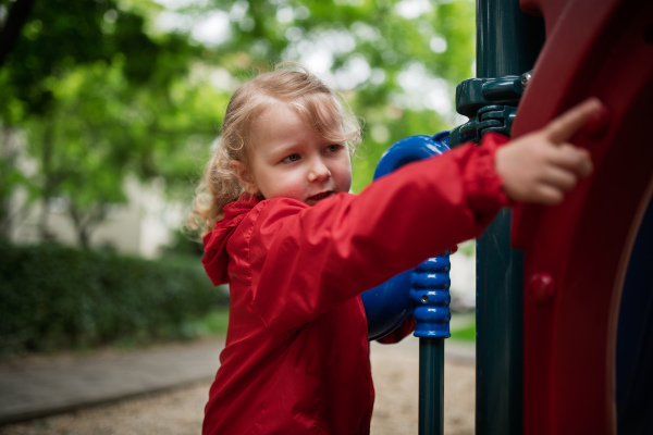Little girl playing on outdoor playground in the city.