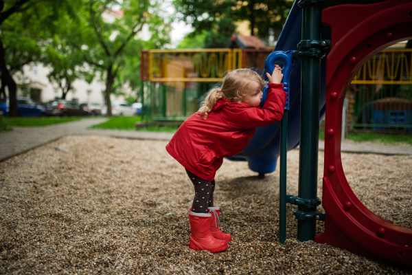 Little girl playing on outdoor playground in the city.