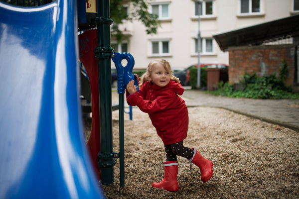 Little girl playing on outdoor playground in the city.