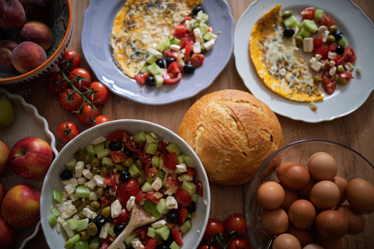 Omelet with Greek salad and fresh bread. Colorful Mediterranean breakfast.