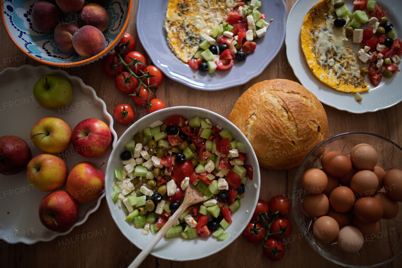 Omelet with Greek salad and fresh bread. Colorful Mediterranean breakfast.