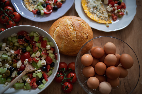 Omelet with Greek salad and fresh bread. Colorful Mediterranean breakfast.