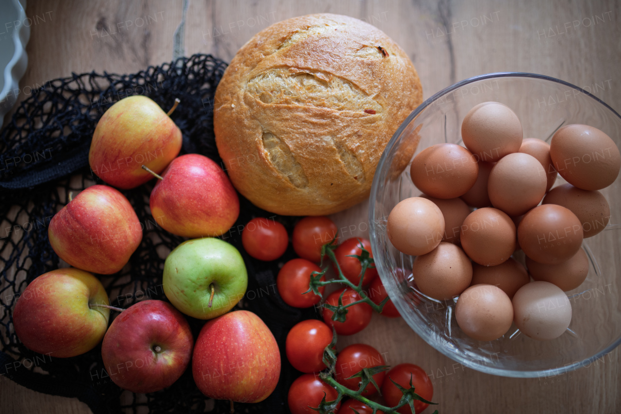 Fresh ingredients for homemade breakfast. Eggs, bread and fruit on rustic wooden table.