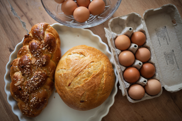 Homemade bread and eggs on rustic kitchen table. Traditional breakfast ingredients.