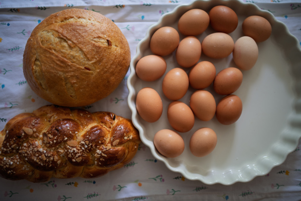 Homemade bread and eggs on rustic kitchen table. Traditional breakfast ingredients.
