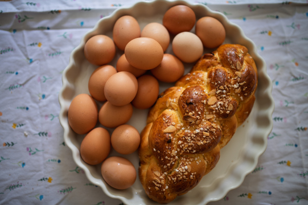 Homemade braided bread and eggs on rustic kitchen table. Traditional breakfast ingredients.