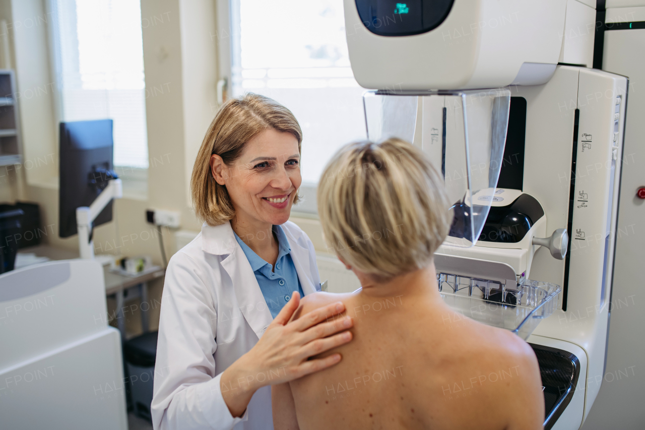 Healthcare professional adjusts the patient for accurate breast imaging. Preventive breast cancer screening.