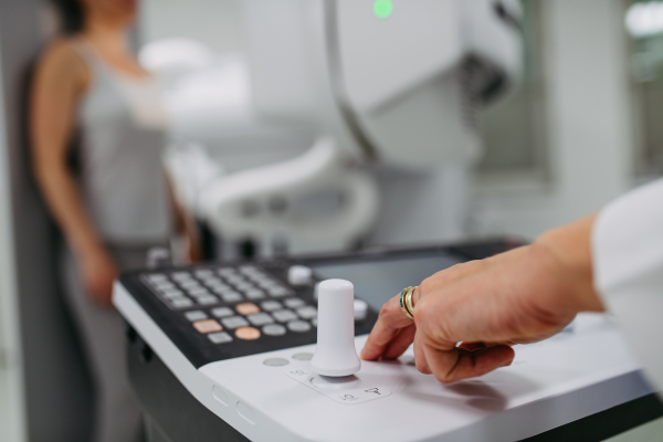 Female doctor operating dynamic X-ray scan using tilting fluoroscopy unit