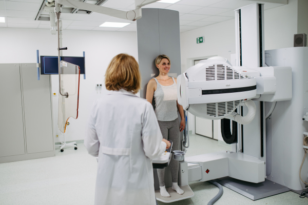 Female doctor operating dynamic X-ray scan using tilting fluoroscopy unit