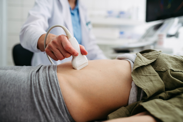 Female patient undergoing abdominal ultrasound screening. Early pregnancy check-up.