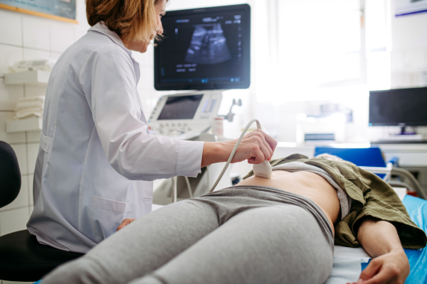 Female patient undergoing abdominal ultrasound screening. Early pregnancy check-up.
