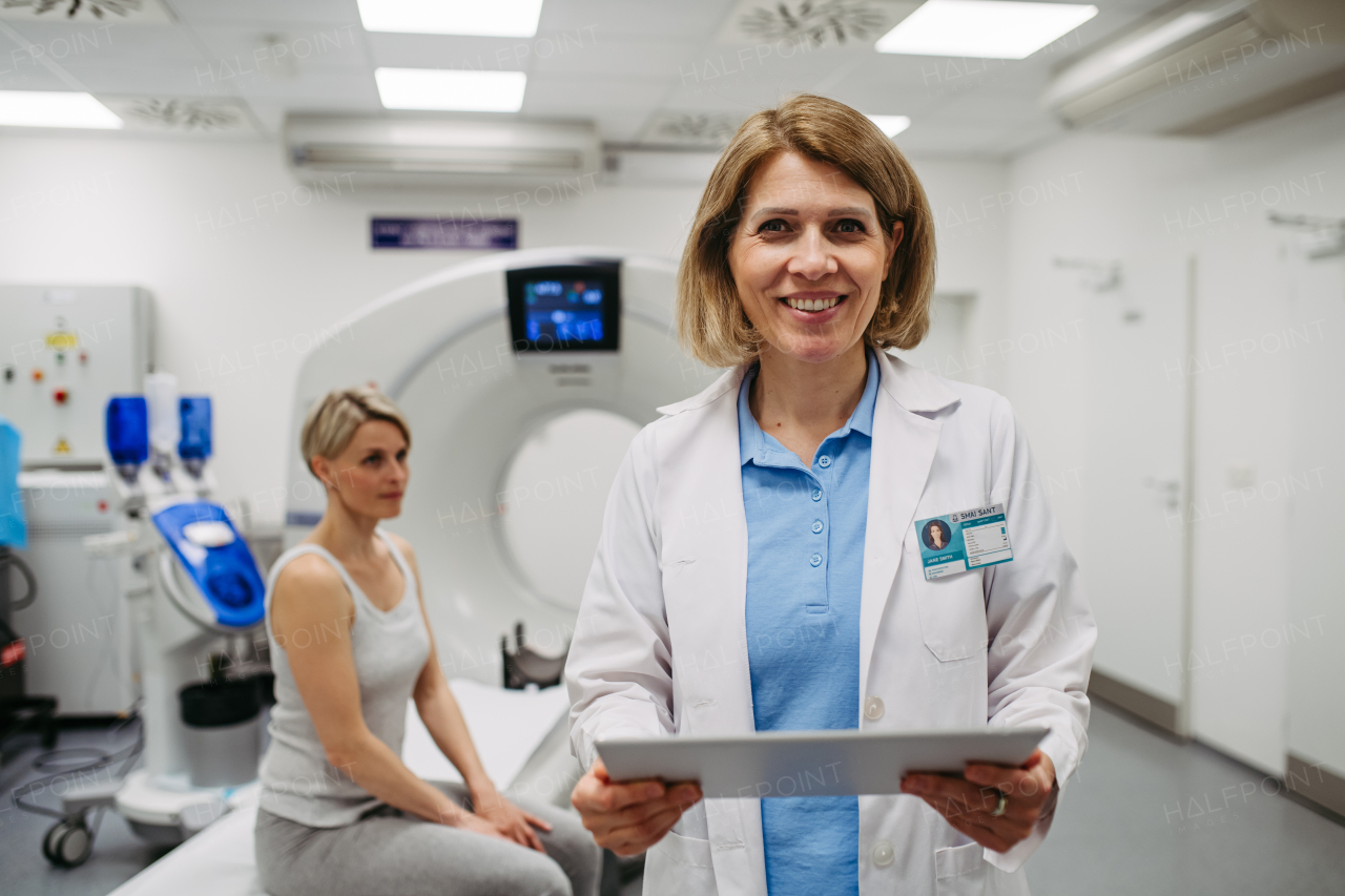 Portrait of female doctor in front of CT scan in radiology exam room.
