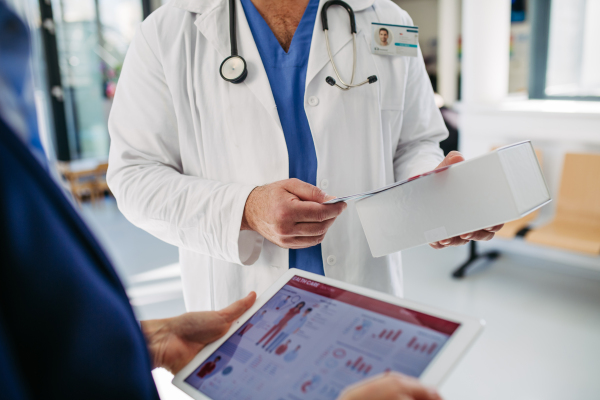 Business interaction between pharma rep and healthcare worker.