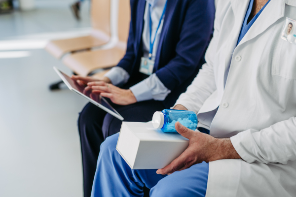 Business interaction between pharma rep and healthcare worker.